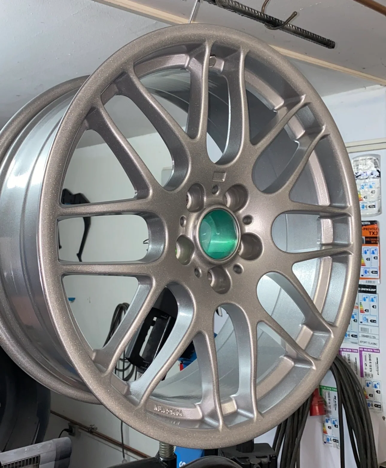 Silber-metallic pulverbeschichtete Kreuzspeichenfelge mit grüner Nabenabdeckung
