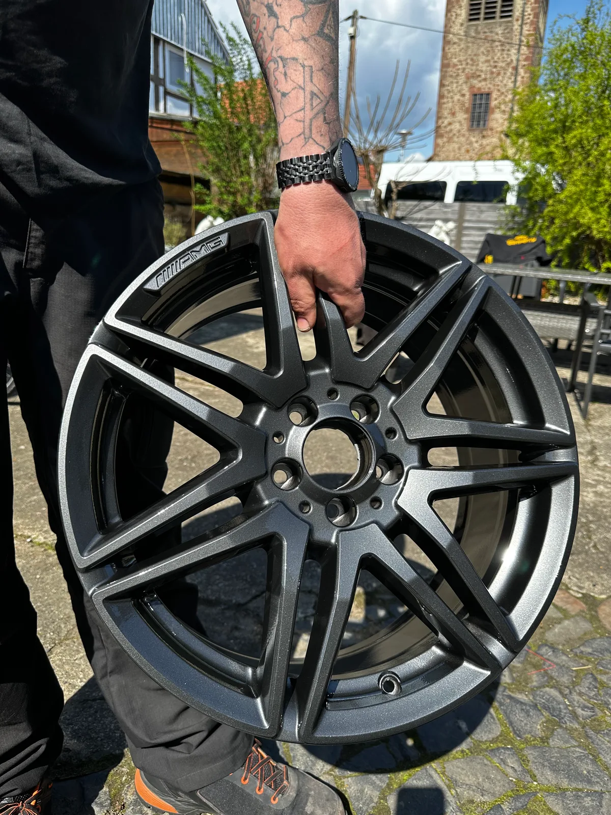 Anthrazit metallic pulverbeschichtete AMG-Felge, im Freien nach der Fertigstellung gehalten