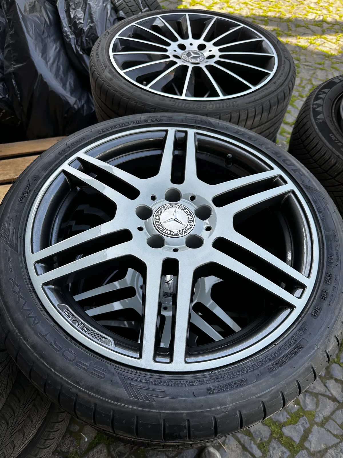 Zwei fertig beschichtete Mercedes-AMG-Felgen mit montierten Reifen im Freien