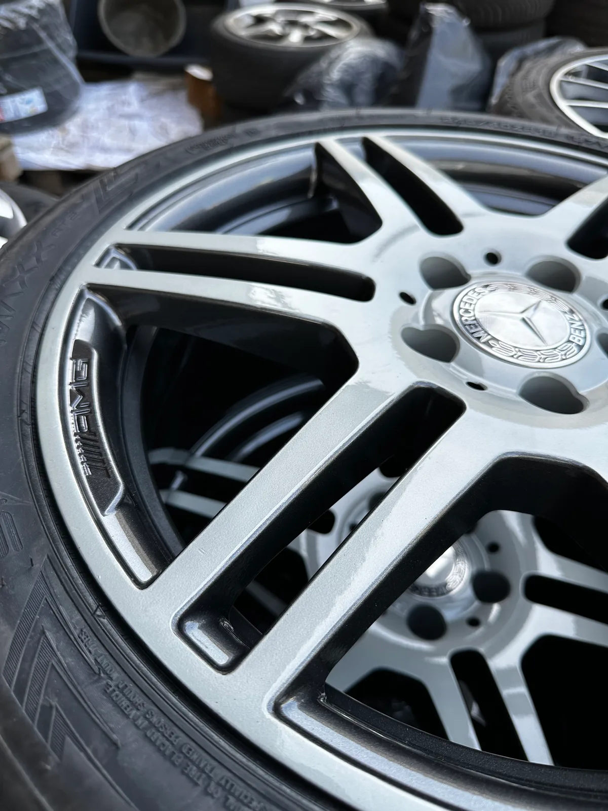 Nahaufnahme einer silber-schwarz beschichteten Mercedes-AMG-Felge mit montiertem Reifen