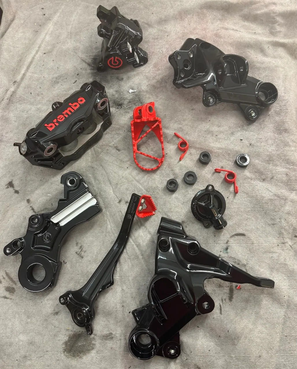 Schwarz pulverbeschichtete Brembo-Bremssättel und Motorradhalterungen mit rot abgesetzten Fußrasten