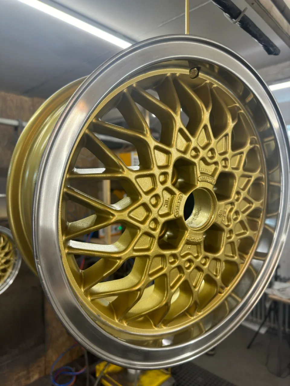 Goldfarben pulverbeschichtete Kreuzspeichenfelge im BBS-Stil mit poliertem Felgenbett