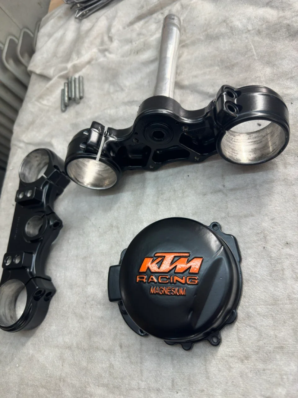 Schwarz pulverbeschichtete KTM-Gabelbrücken und Kupplungsdeckel mit orangefarbenem Racing-Schriftzug